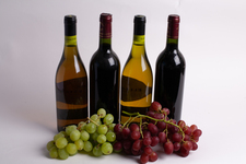 Four bottles of wine, with grapes